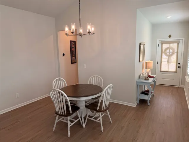 A refined chandelier illuminates the dining area, featuring attractive LVP flooring leading to a welcoming entry. 15x11