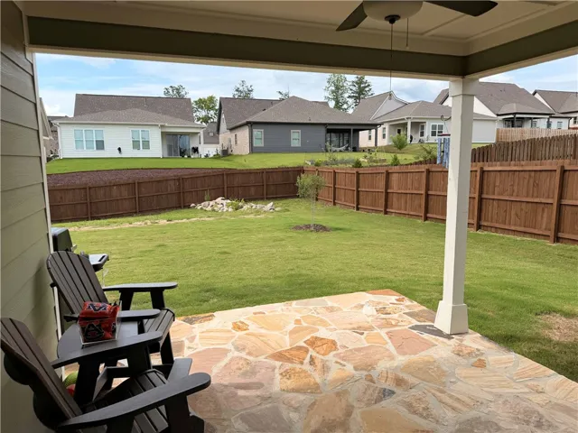 Enjoy Auburn sunsets on the flagstone extended patio with a ceiling fan surrounded by a manicured lawn and privacy fencing.