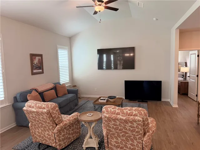 Vaulted ceilings elevate this well-lit living room, offering an inviting atmosphere with newly added plantation shutters. 15x15