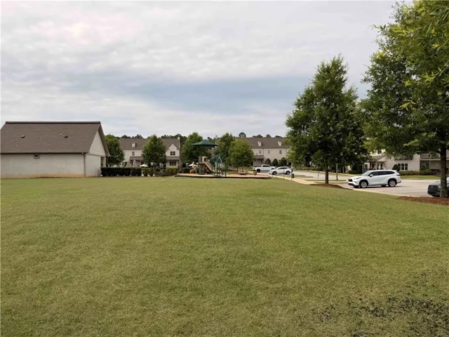 Green space abounds with community playground and residential street access.