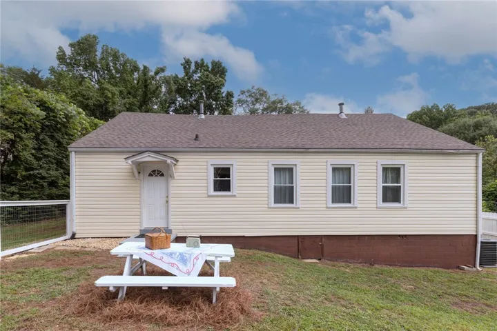A quaint residence with light siding and a picnic area, perfect for outdoor enjoyment.