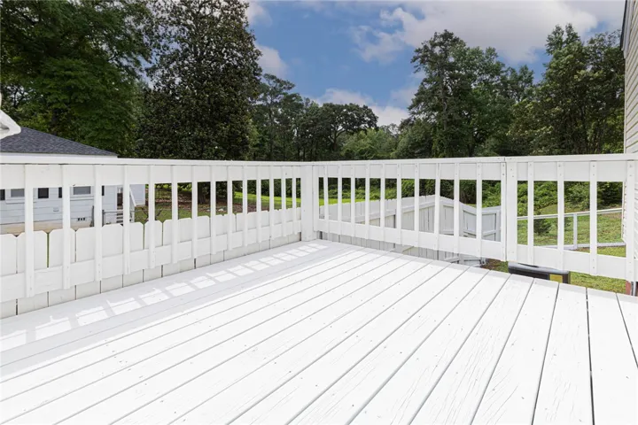A pristine white deck extends into a lush, private yard, perfect for outdoor enjoyment.