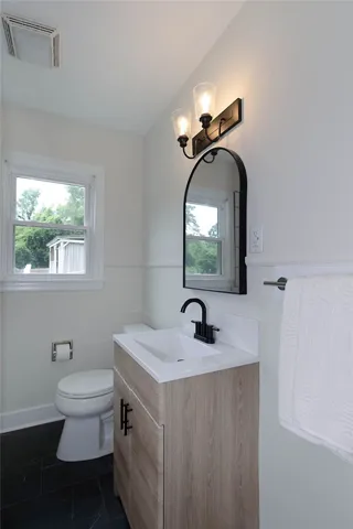 A well-lit bathroom with contemporary fixtures and a window providing natural light.
