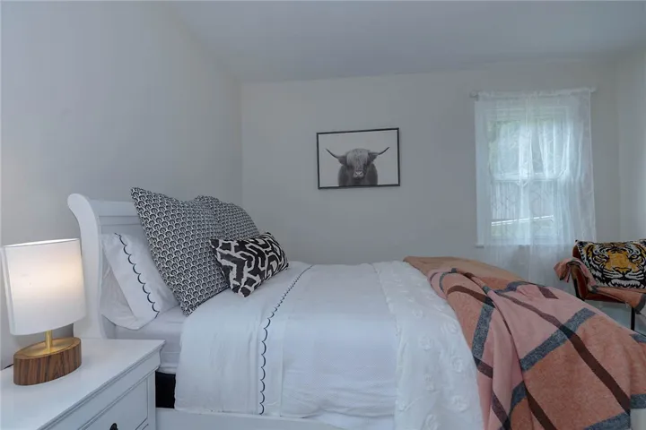 A well-lit bedroom provides a restful retreat, featuring a window with natural illumination.
