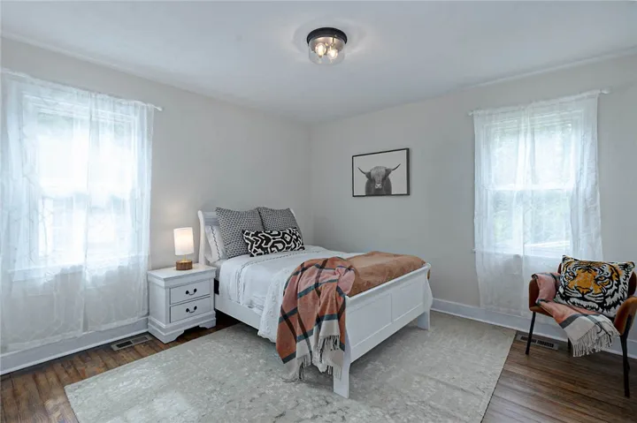 Hardwood floors and bright windows create a cozy, inviting bedroom retreat.