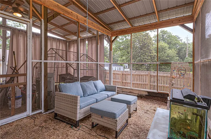 Relax and unwind in this inviting screened porch, offering serene views of the fenced backyard.
