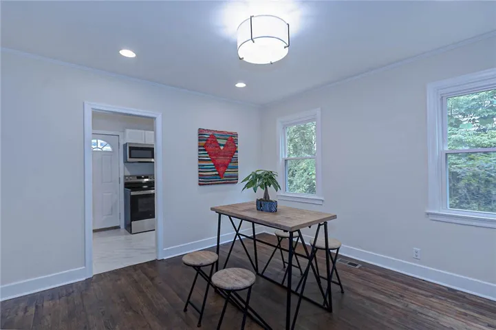 Natural light filters through twin windows into this charming dining space, ideal for casual meals.
Original oak hardwoods restored