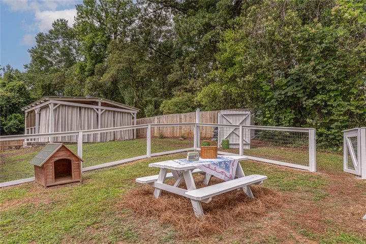 A private, fenced outdoor area offers a charming picnic table and shaded outbuilding for relaxed enjoyment.