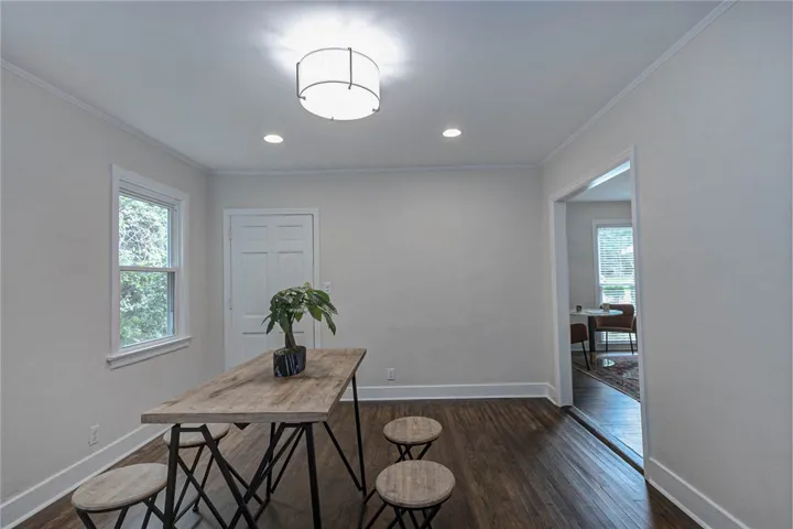 Rich hardwood floors lead into this versatile space, featuring elegant crown molding and recessed lighting.