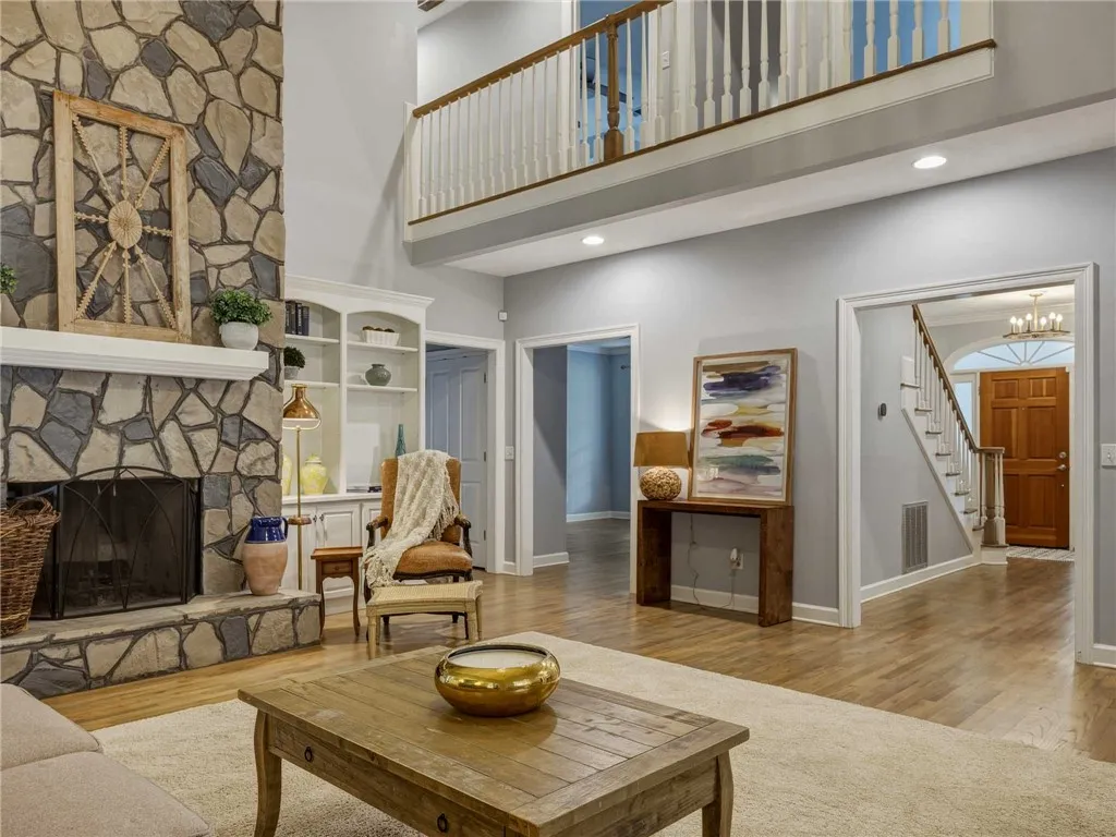 Soaring ceilings and a floor-to-ceiling stone fireplace anchor this warm living room.