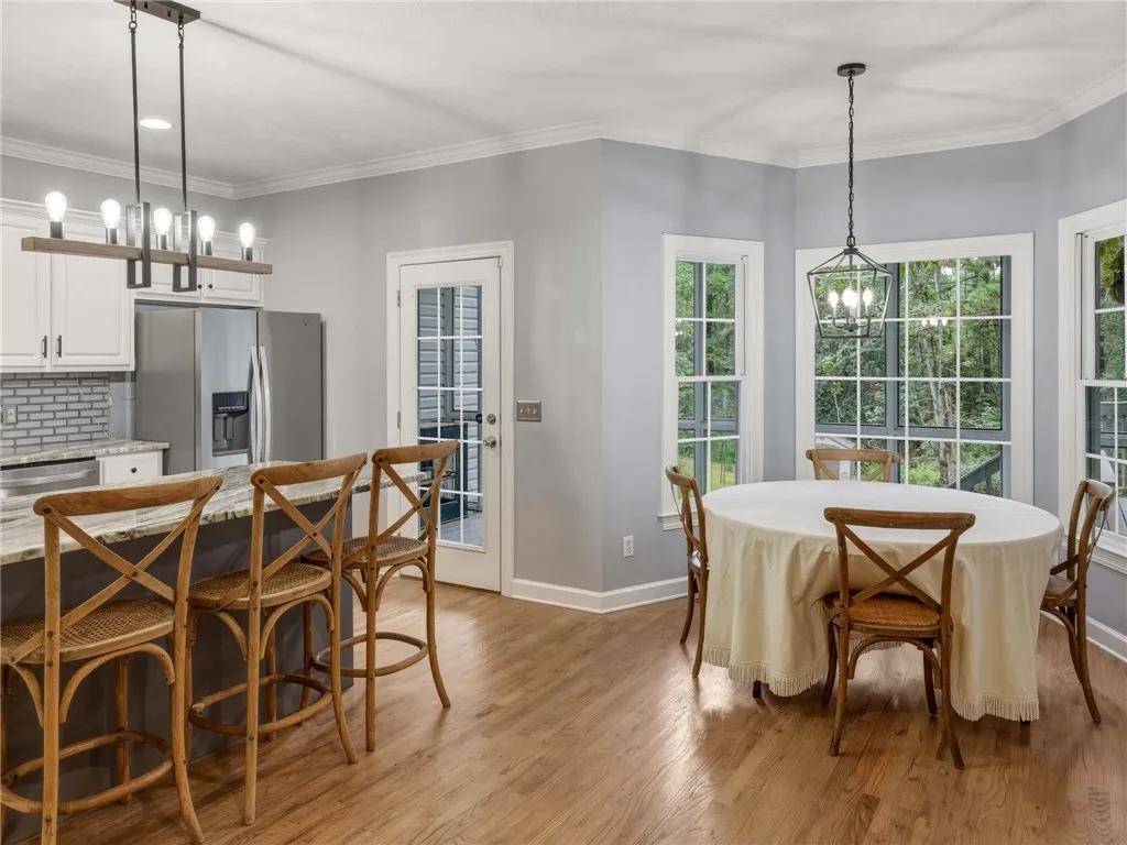 Rich hardwood floors complement the bright breakfast area flowing into a well-appointed kitchen.