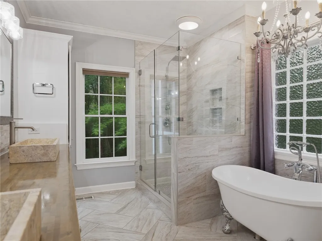 Elegant bathroom features a glass-enclosed walk-in shower and a classic clawfoot tub.