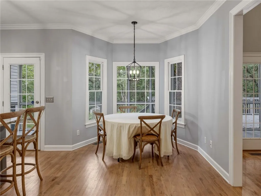Gleaming hardwood floors and classic crown molding frame this inviting breakfast area with bay windows.