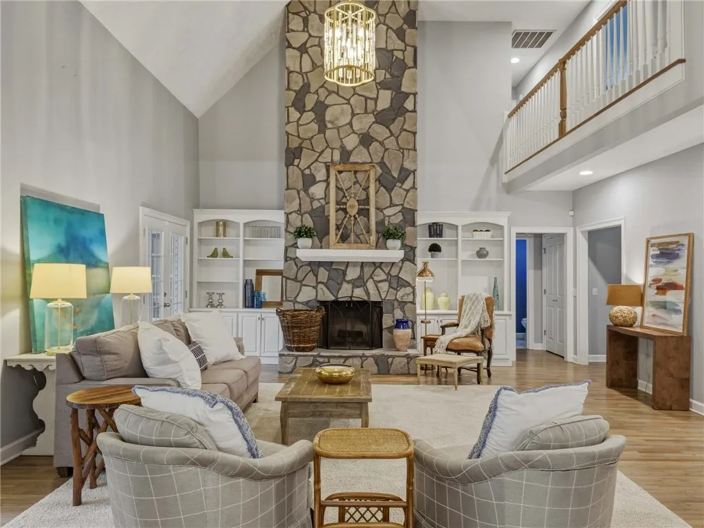 A floor-to-ceiling stone fireplace serves as the centerpiece of this vaulted living area.
