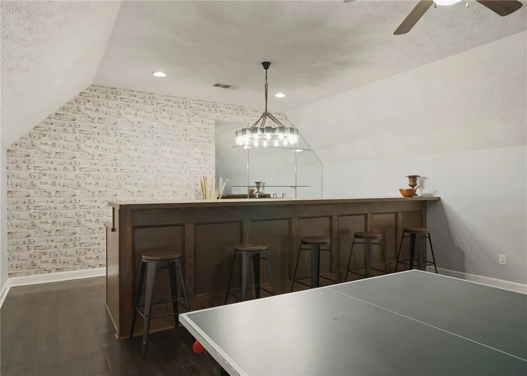 Gleaming hardwood floors and a built-in bar enhance this versatile upper-level recreation room.