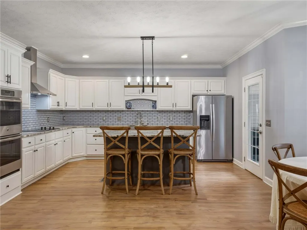 Hardwood floors and crisp white cabinetry define this beautifully updated culinary space.