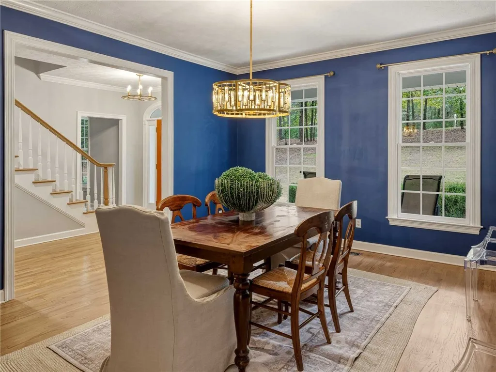 Rich hardwood flooring and classic crown molding elevate this elegant formal dining room.