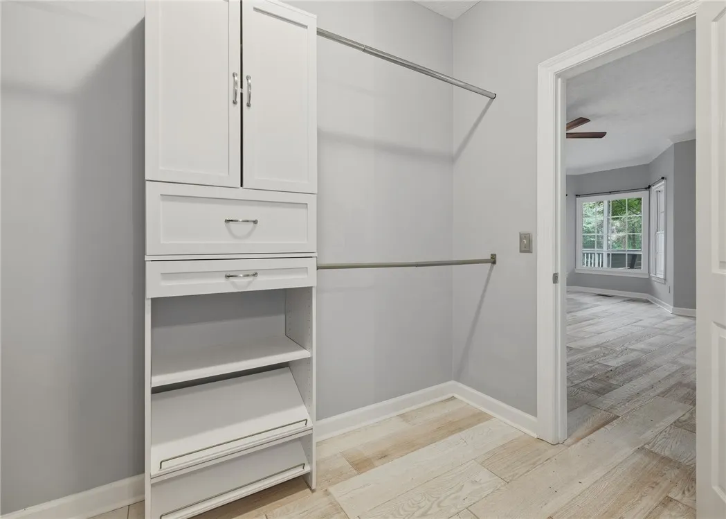 Custom built-in cabinetry and hanging rods maximize storage in this walk-in closet space.