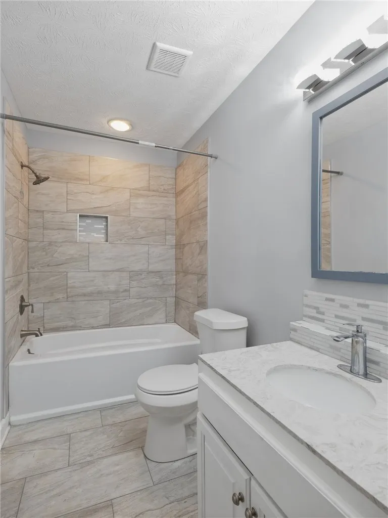 Clean stone countertops and modern tile work elevate this updated bathroom space.