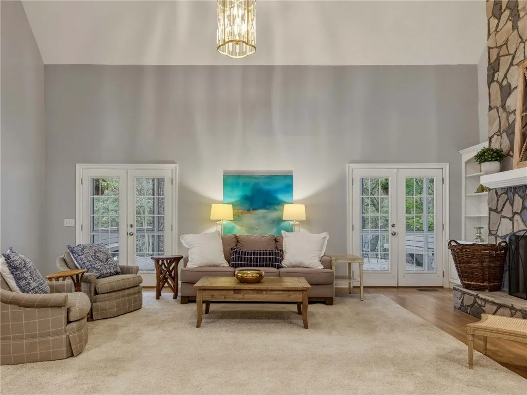 Double French doors and a floor-to-ceiling stone fireplace accent this vaulted living room.