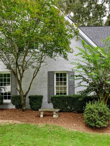 Mature trees frame the classic brick exterior of this traditional home.