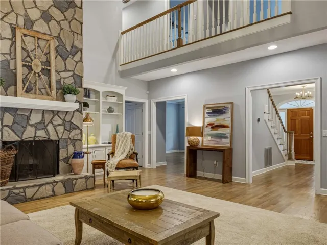 Soaring ceilings and a floor-to-ceiling stone fireplace anchor this warm living room.