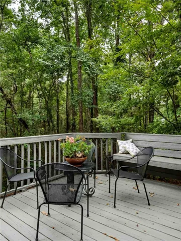 A spacious wooden deck looks out over a dense, serene forest backdrop.