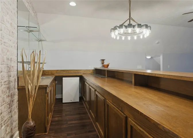 Gleaming wood counters and brick accent details define this functional built-in home bar space.