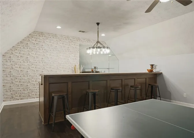 Gleaming hardwood floors and a built-in bar enhance this versatile upper-level recreation room.
