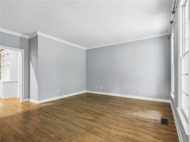 Rich hardwood flooring and classic crown molding define this versatile living space.