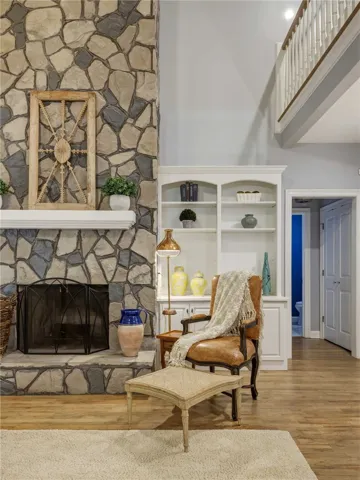 High ceilings and a towering stone fireplace create a grand focal point in this living area.