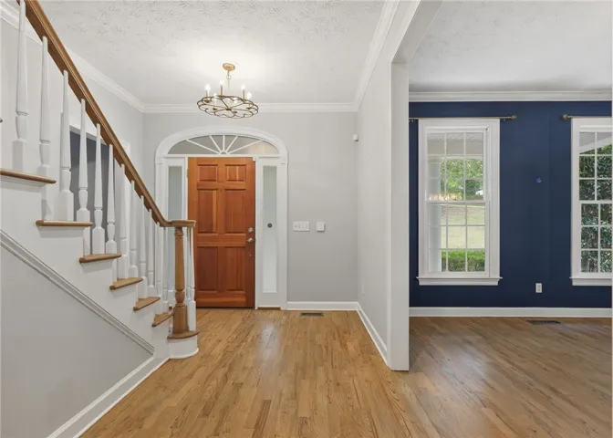 Rich hardwood flooring guides the way through this classic entry hall.
