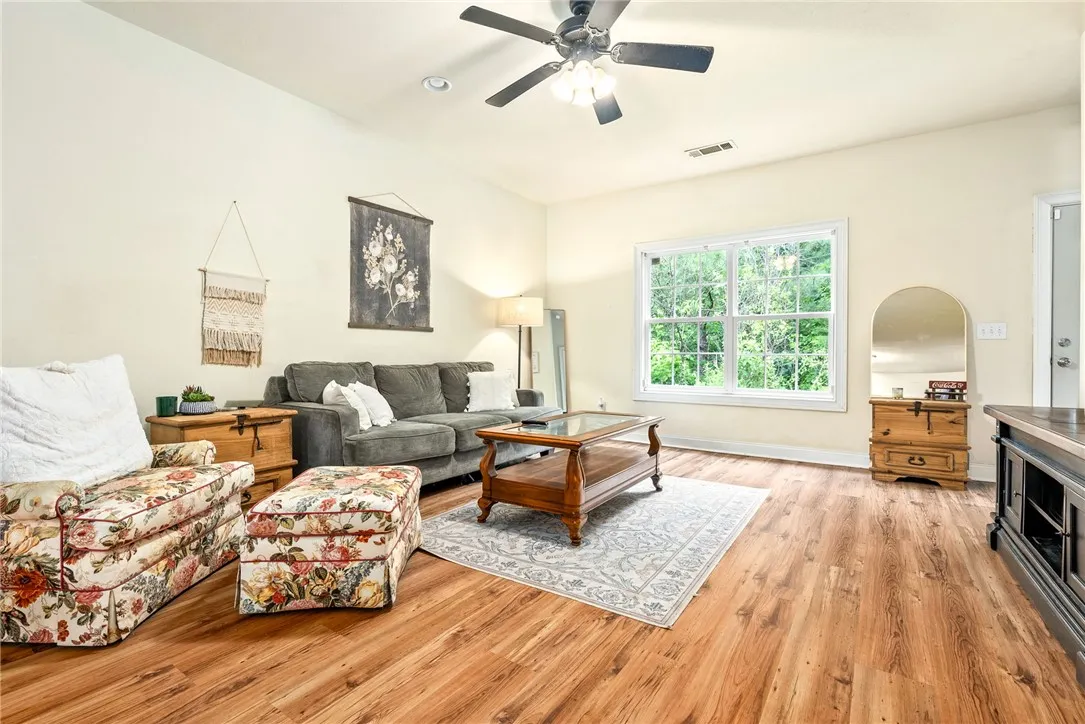 Luminous living area features gleaming hardwood floors and ample natural illumination from a large picture window.
