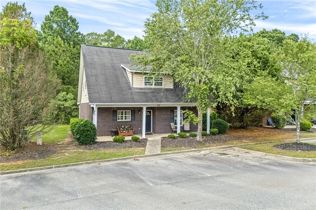 A charming exterior with a classic brick facade and inviting covered front porch awaits new occupants.