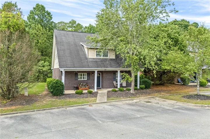 A charming exterior with a classic brick facade and inviting covered front porch awaits new occupants.