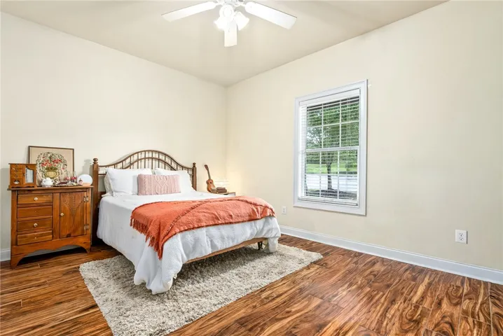 Rich hardwood floors complement this naturally illuminated bedroom, offering a peaceful retreat.