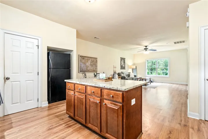 A well-appointed kitchen island offers generous counter space and storage, flowing seamlessly into the adjacent living area.