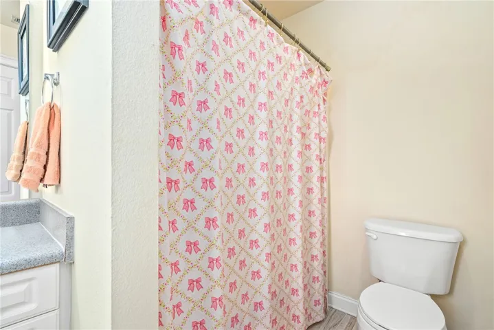 Functional full bathroom with shower curtain and sleek toilet.