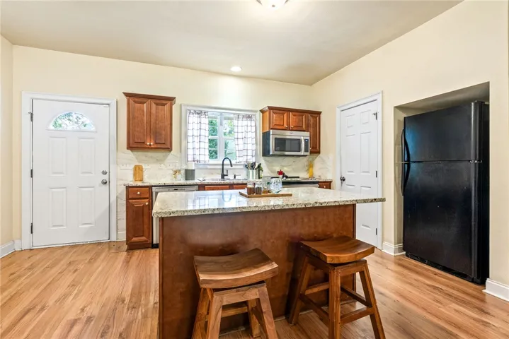 A functional kitchen features an island, ample counter space, and durable wood flooring.