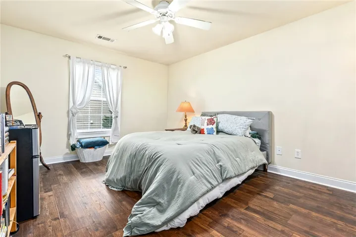 Hardwood floors and a ceiling fan create a comfortable and cool bedroom retreat.