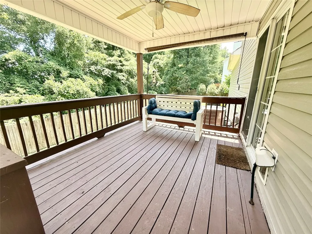 An inviting covered deck offers serene treetop views, perfect for relaxation.