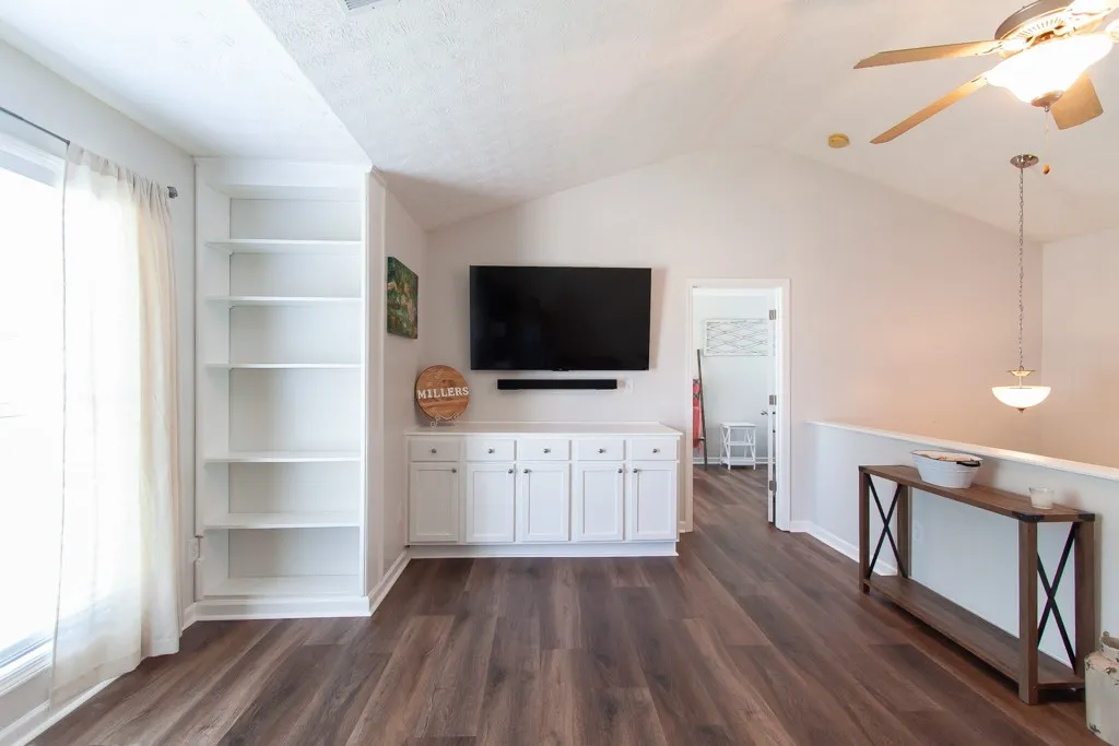 LVP flooring complements a well-lit living area/ loft featuring built-in shelving and ample natural light.