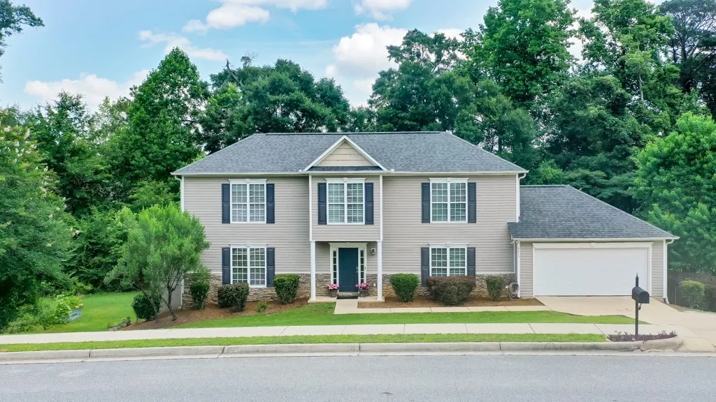 A classic two-story residence presents with tidy landscaping and a spacious