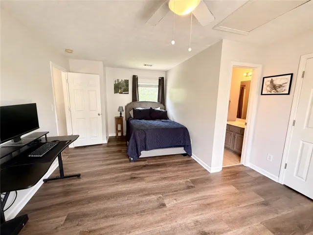 Relax in this well-appointed bedroom featuring attractive LVP flooring and convenient access to a private bathroom.