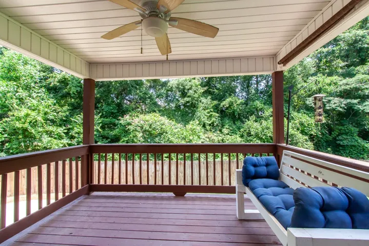 An inviting covered deck offers serene treetop views, perfect for relaxation.
