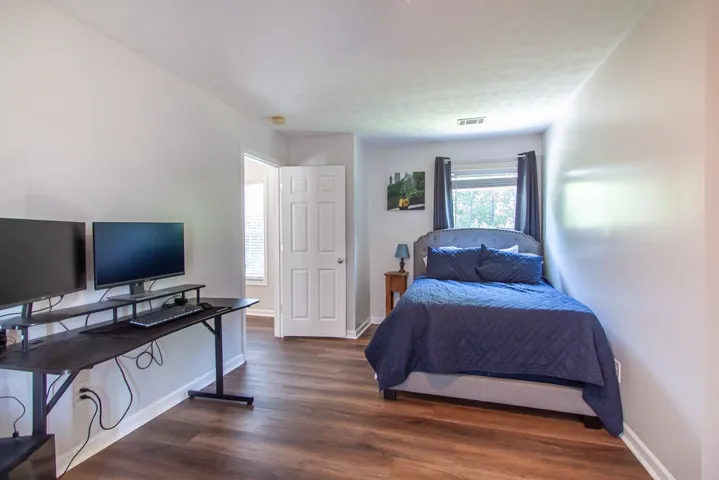 Well-appointed bedroom showcasing durable flooring and a window with natural light.