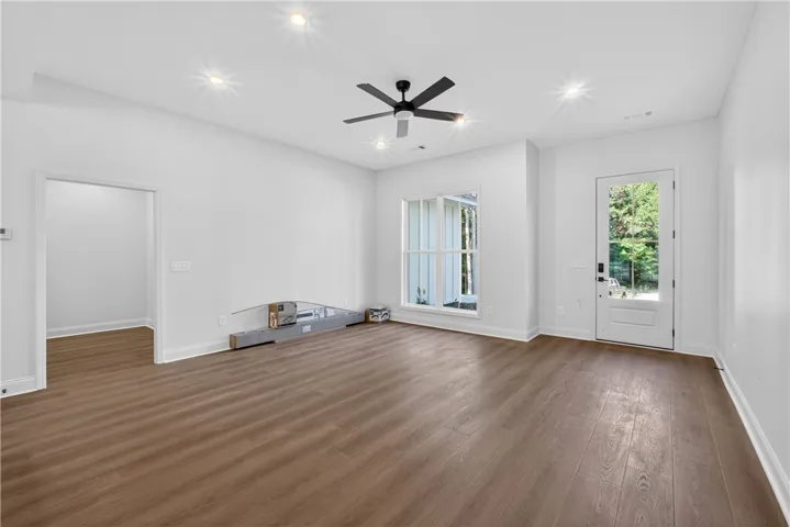 A well-lit interior space with sleek wood flooring offers a versatile living area.