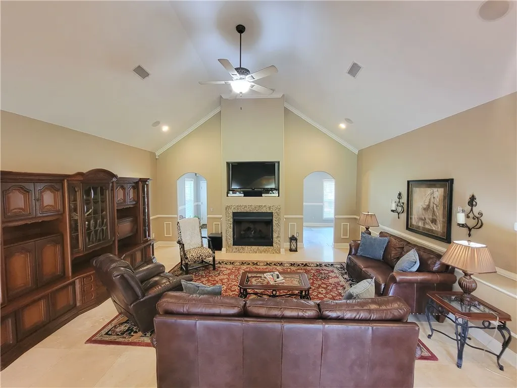 A striking fireplace forms the focal point in this welcoming living area, complemented by high vaulted ceilings.