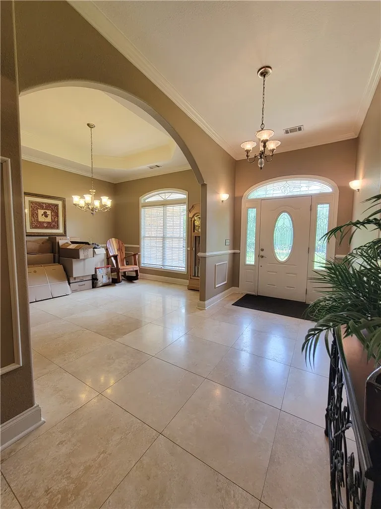 Step into a luminous entryway featuring an arched doorway and polished tile flooring.