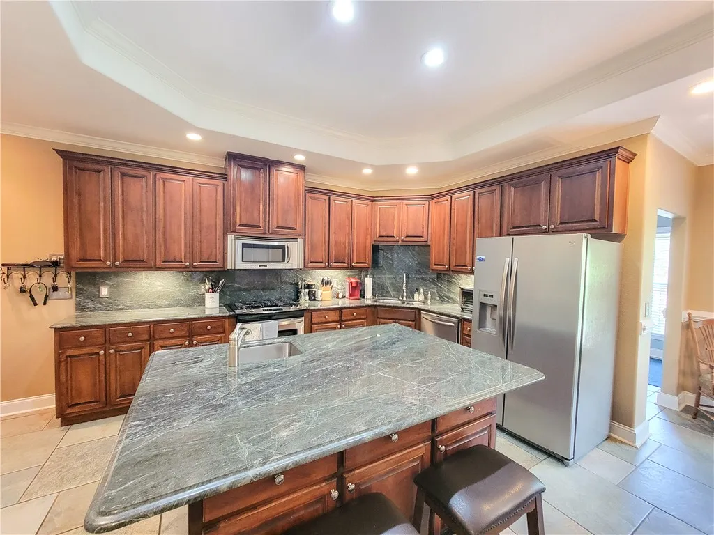 Culinary delights await in this chef's kitchen featuring a spacious island and gleaming stainless steel appliances.